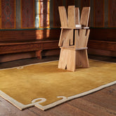 Luxury solid brown area rug with abstract corner design.
